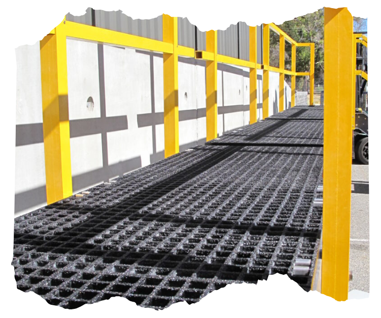 Industrial safety walkway with yellow railings and non-slip grating for secure pedestrian access, designed for commercial or construction settings.